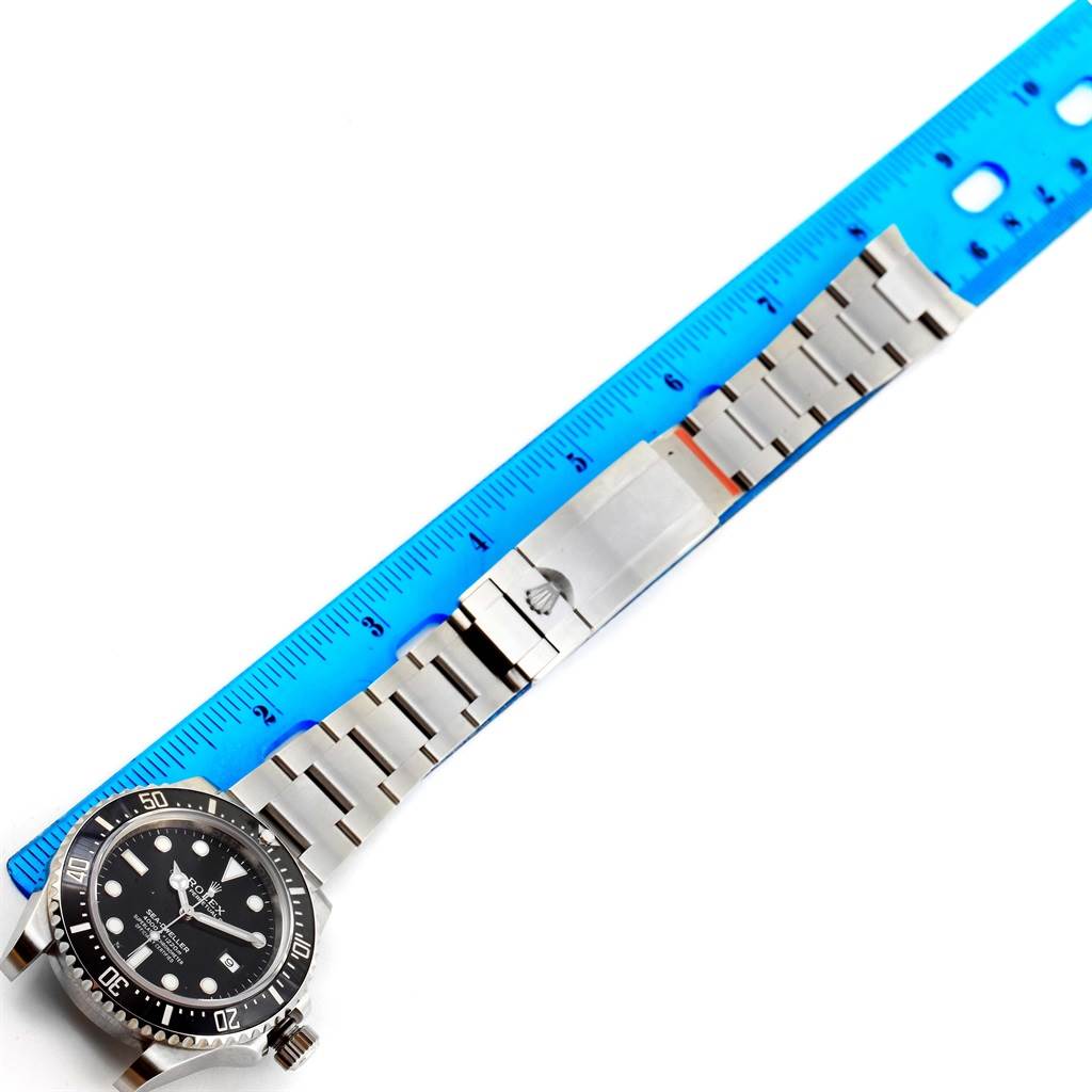 The image shows a Rolex Sea-Dweller 116600 Men's Stainless Steel Black Dial 116600 Men's Stainless Steel Black Dial watch with its bracelet alongside a blue ruler for scale.