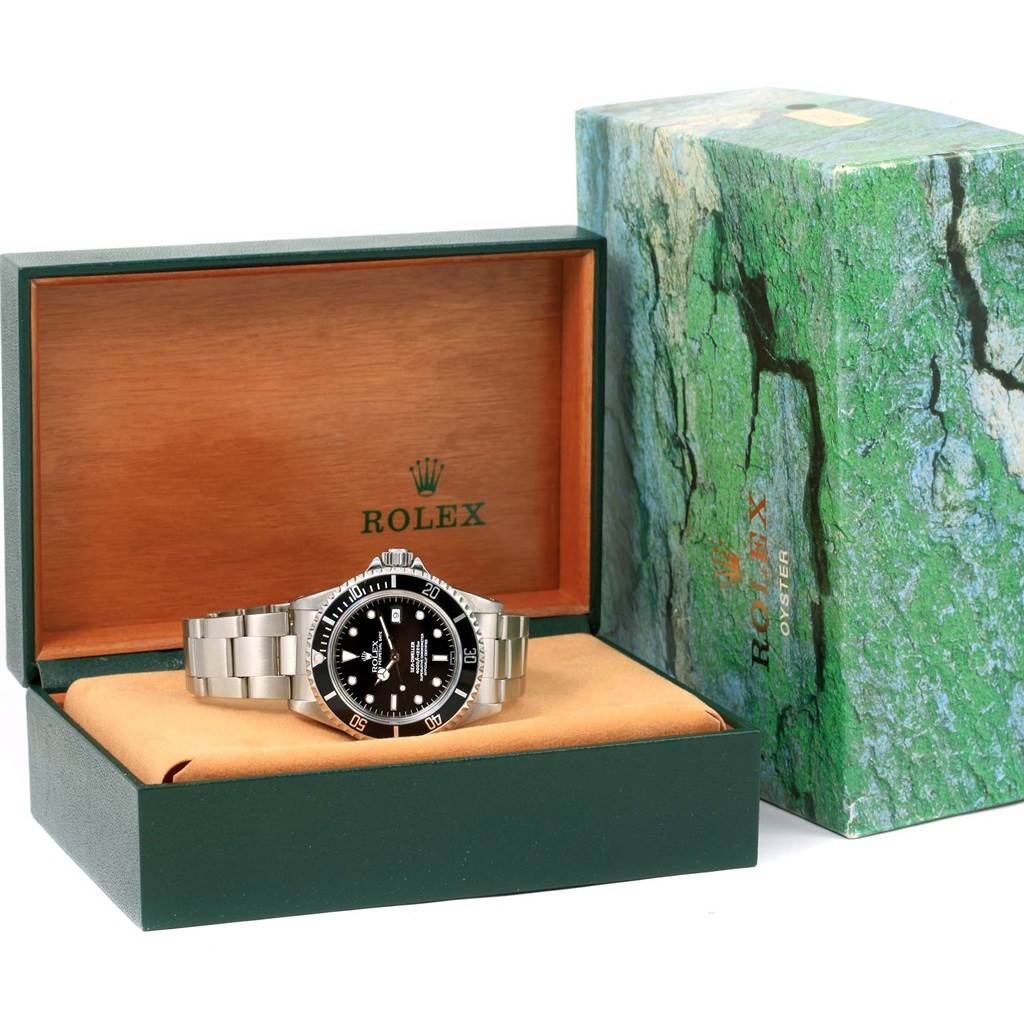 The watch shown is a Rolex Sea-Dweller 16600 Men's Stainless Steel Black Dial 16600 Men's Stainless Steel Black Dial, displayed in its open green box with a green and stone-pattern outer box.