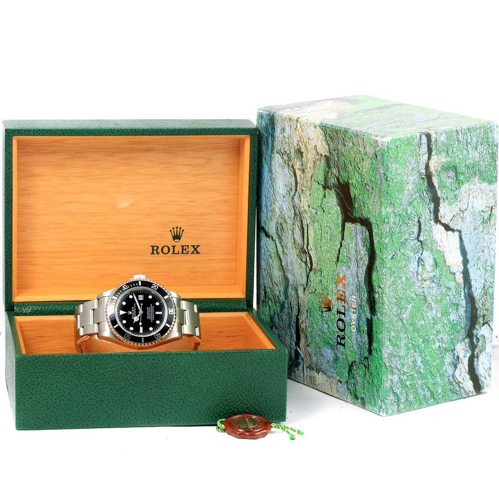 The image shows a Rolex Sea-Dweller 16600 Men
s Stainless Steel Black Dial 16600 Men
s Stainless Steel Black Dial watch placed inside an open green display box with a partially visible green outer box.