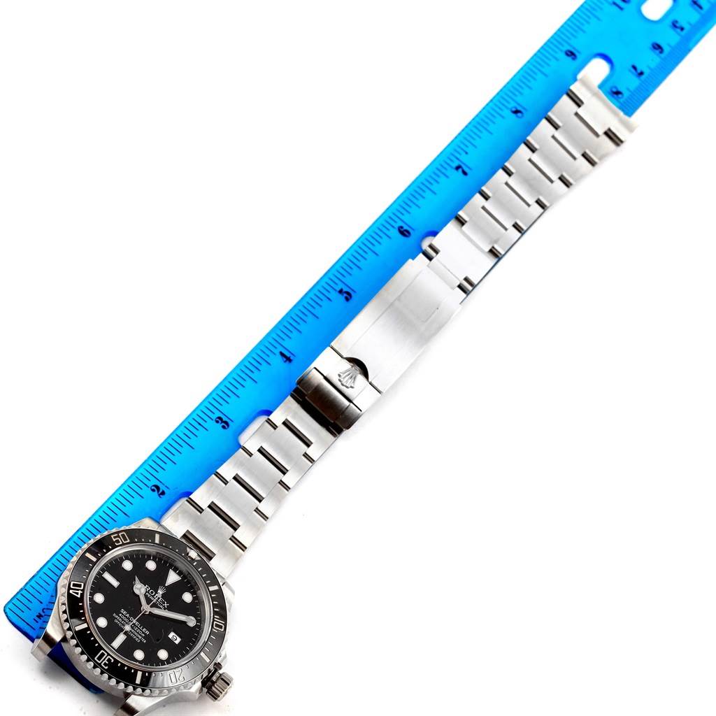 The Rolex Sea-Dweller 116600 Men's Stainless Steel Black Dial 116600 Men's Stainless Steel Black Dial watch is shown from above, displaying the face, bracelet, and clasp alongside a blue ruler for scale.