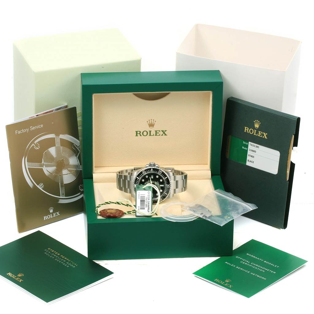 The image shows a Rolex Sea-Dweller 116600 Men
s Stainless Steel Black Dial 116600 Men
s Stainless Steel Black Dial watch at a frontal angle, inside its box with accompanying booklets and accessories.