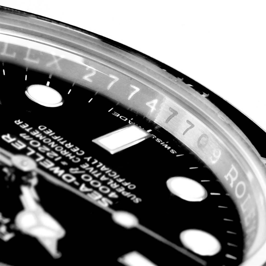 This close-up angle of the Rolex Sea-Dweller 116600 Men
s Stainless Steel Black Dial 116600 Men
s Stainless Steel Black Dial watch shows part of the dial, indices, and the Rehaut with engraving.