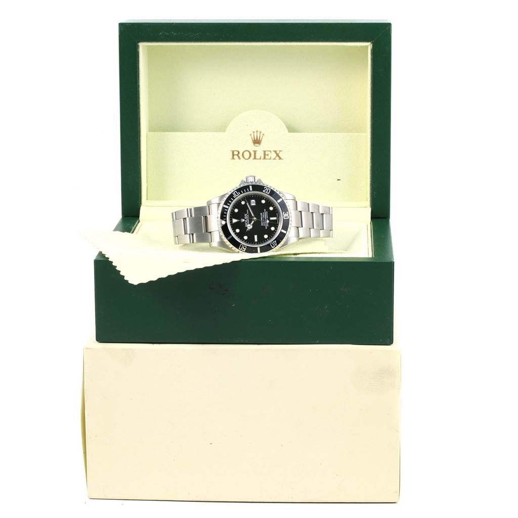 The Rolex Sea-Dweller 16600 Men
s Stainless Steel Black Dial 16600 Men
s Stainless Steel Black Dial watch is shown from a front angle, displayed inside an open green and cream box.