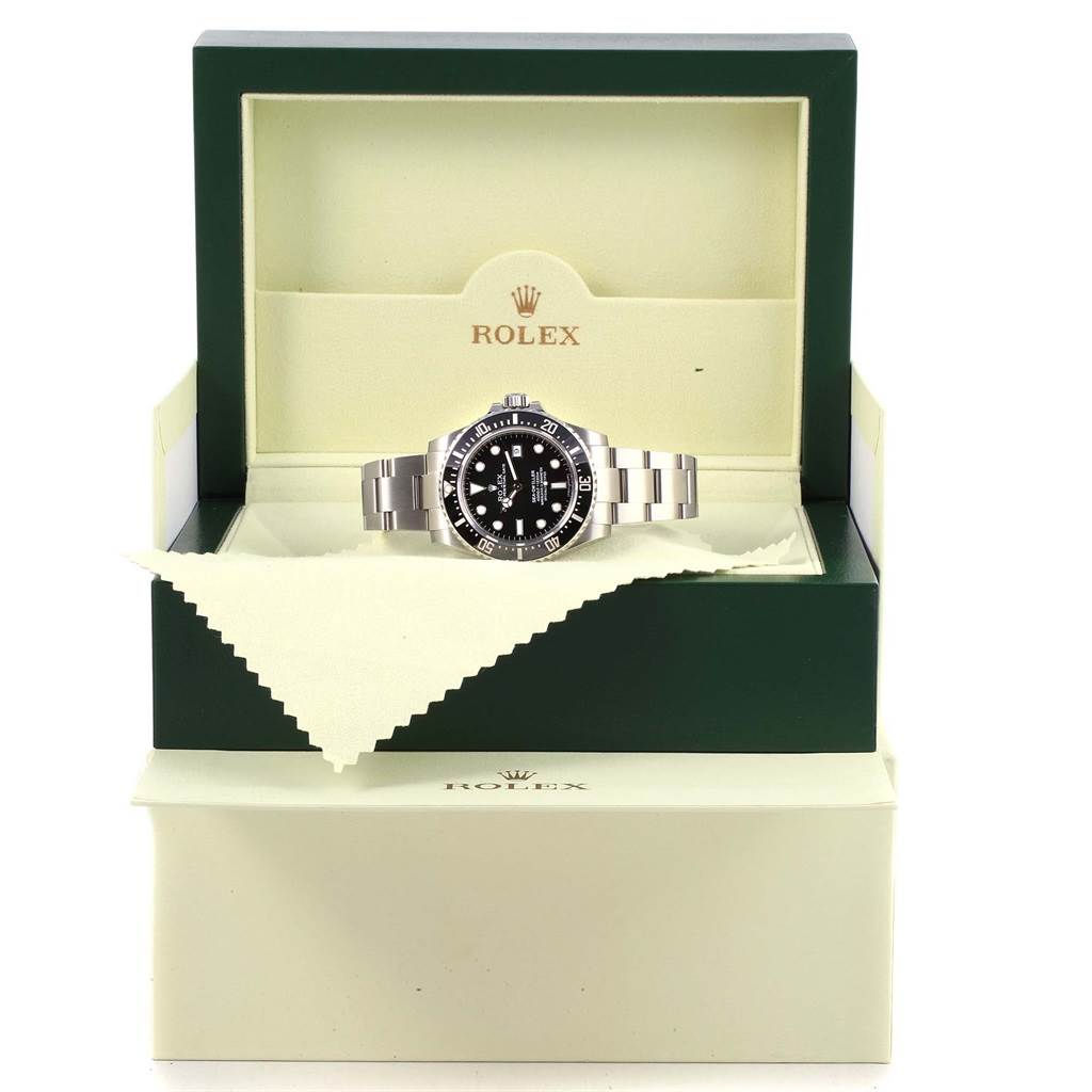 The Rolex Sea-Dweller 116600 Men's Stainless Steel Black Dial 116600 Men's Stainless Steel Black Dial watch is shown from the front inside its green and cream-colored display box with a cleaning cloth.