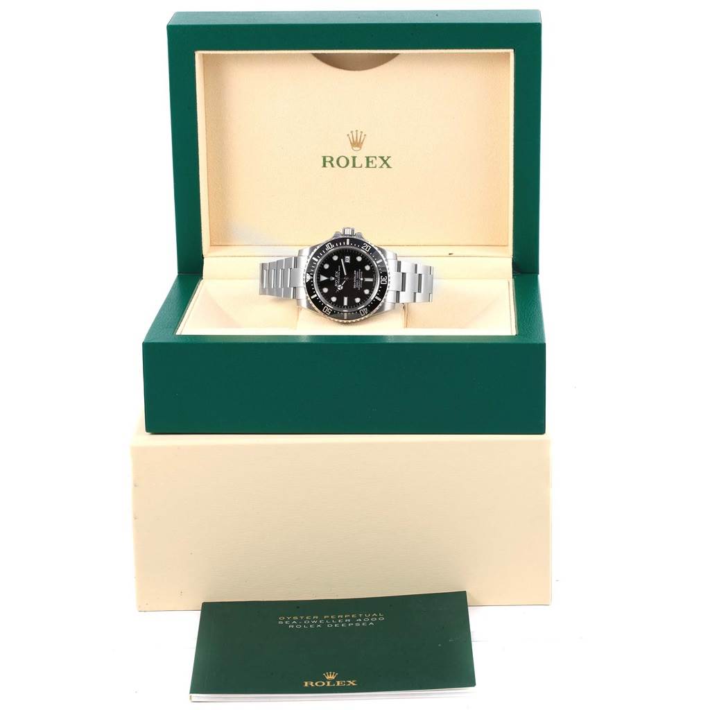 The Rolex Sea-Dweller 116600 Men's Stainless Steel Black Dial 116600 Men's Stainless Steel Black Dial watch is shown in its open luxury box along with a booklet in the foreground.