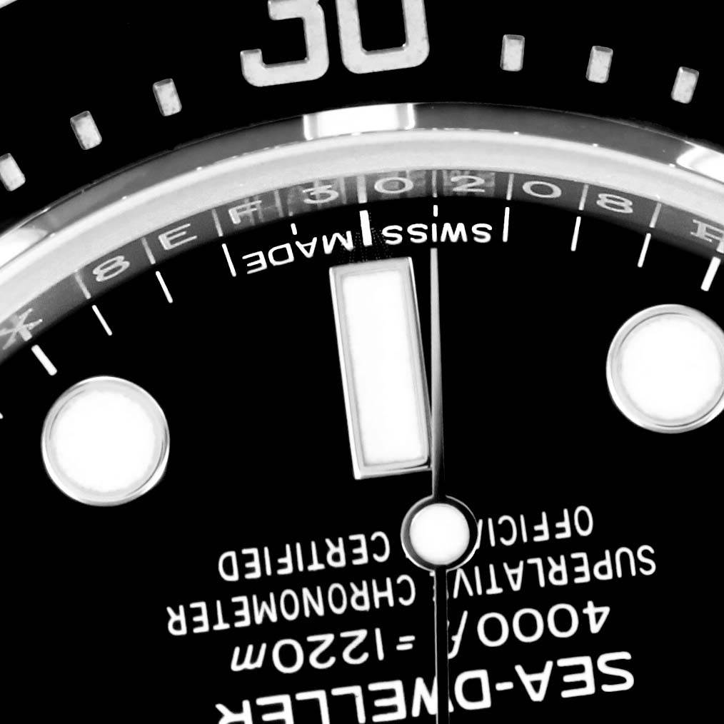 This close-up image shows the dial and part of the bezel of a Rolex Sea-Dweller 116600 Men's Stainless Steel Black Dial 116600 Men's Stainless Steel Black Dial watch.