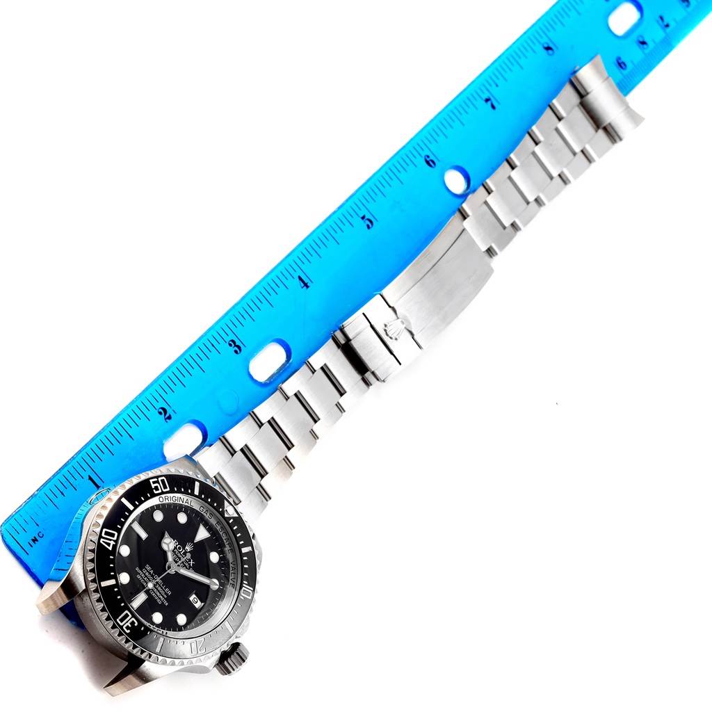 The image shows a Rolex Sea-Dweller 116660 Men's Stainless Steel Black Dial 116660 Men's Stainless Steel Black Dial watch laying flat with a blue ruler for scale, highlighting its face and bracelet.