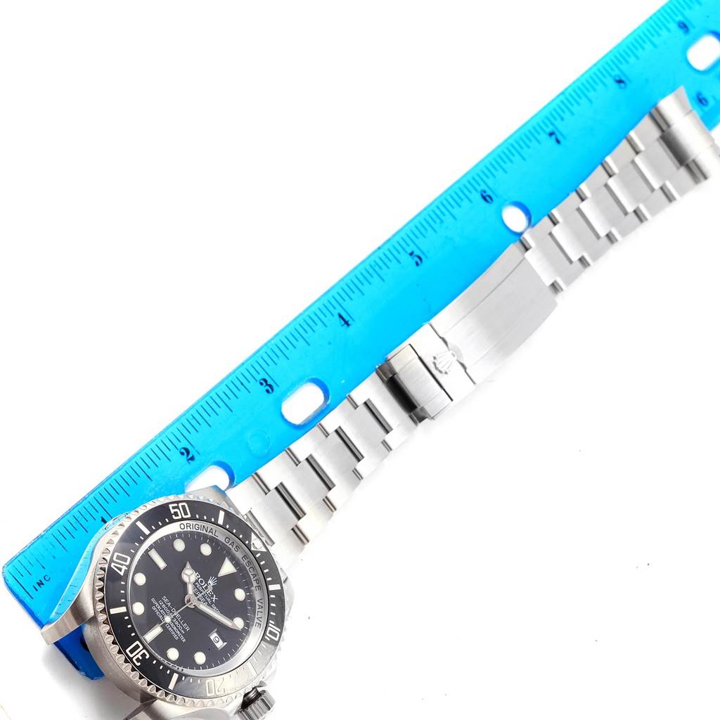 The image shows a flat view of a Rolex Sea-Dweller 116660 Men's Stainless Steel Black Dial 116660 Men's Stainless Steel Black Dial watch with its metal bracelet and a blue ruler for scale.