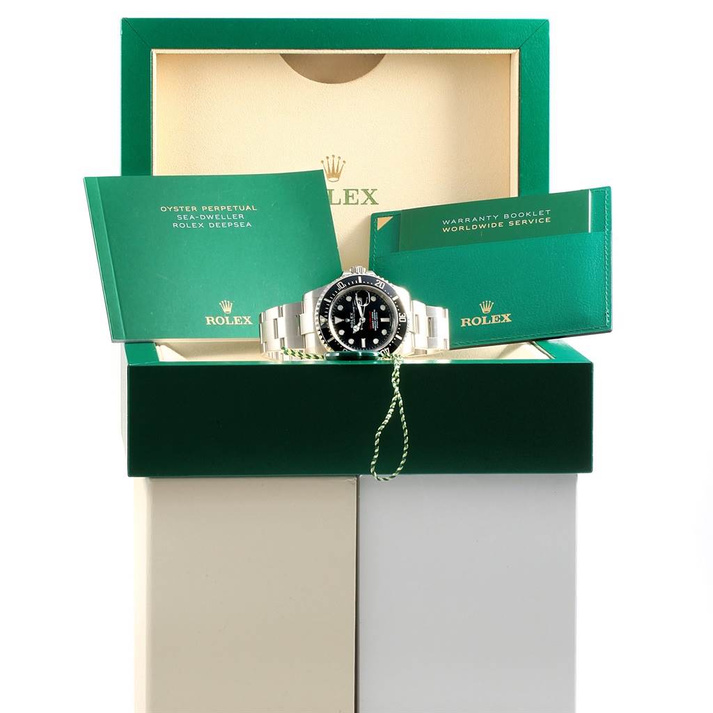 The image shows a Rolex Sea-Dweller 126600 Men
s Stainless Steel Black Dial 126600 Men
s Stainless Steel Black Dial watch positioned in its box with accompanying booklets and warranty card.