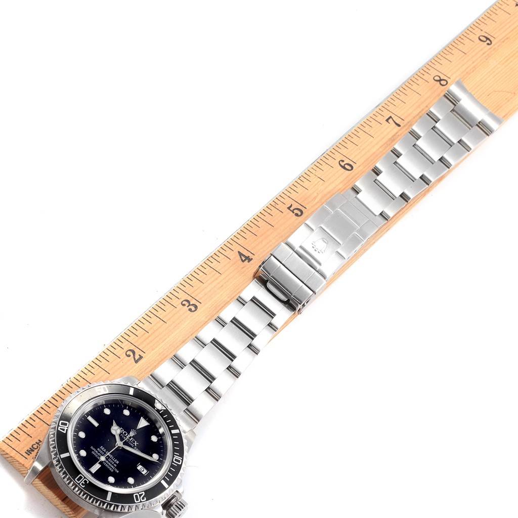 The image shows a Rolex Sea-Dweller 16600 Men
s Stainless Steel Black Dial 16600 Men
s Stainless Steel Black Dial watch positioned next to a ruler, highlighting its face, bezel, and bracelet.