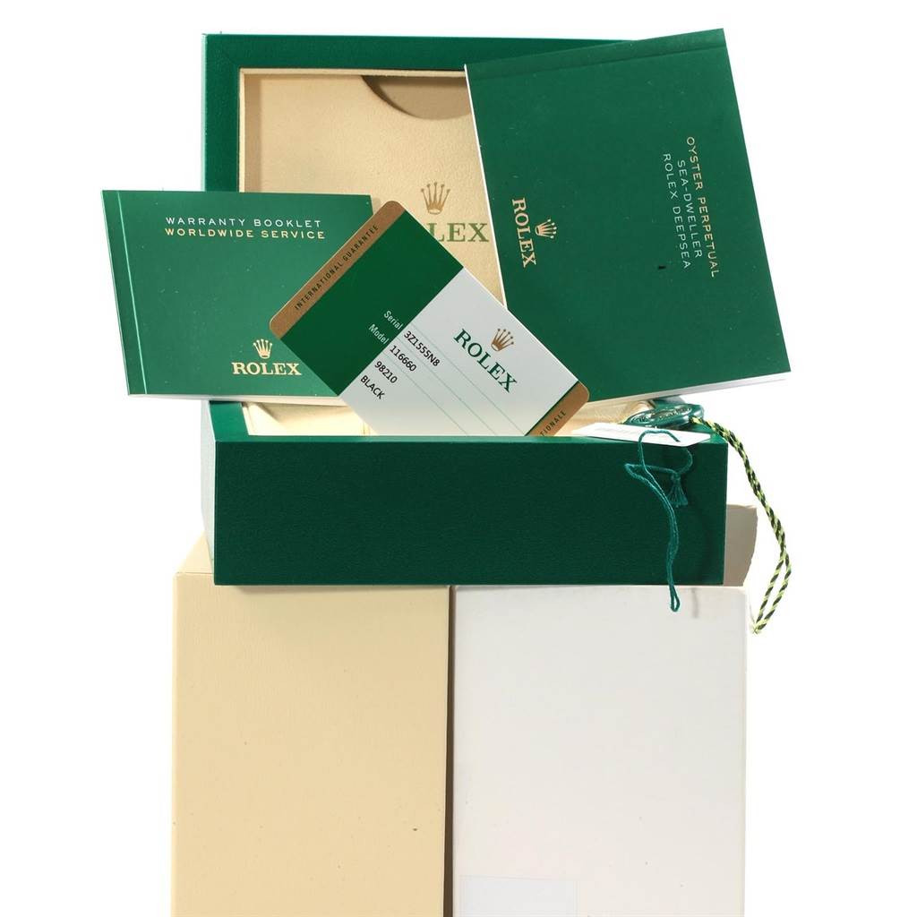 The image shows the packaging and accessories for a Rolex Sea-Dweller 116660 Men
s Stainless Steel Black Dial 116660 Men
s Stainless Steel Black Dial, including warranty booklets and the watch
s tag.