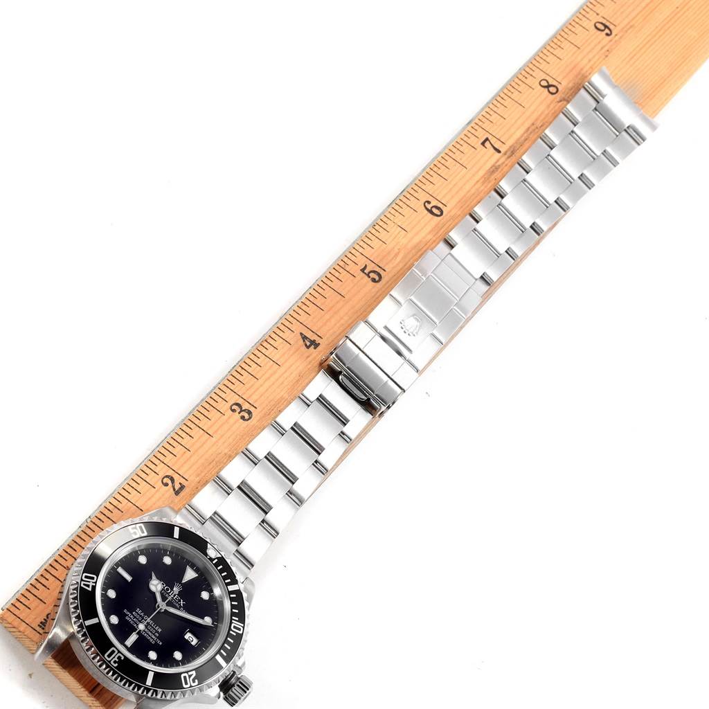 This image shows a Rolex Sea-Dweller 16600 Men
s Stainless Steel Black Dial 16600 Men
s Stainless Steel Black Dial watch laid flat with its bracelet aligned along a ruler, displaying the watch
s face and full bracelet.