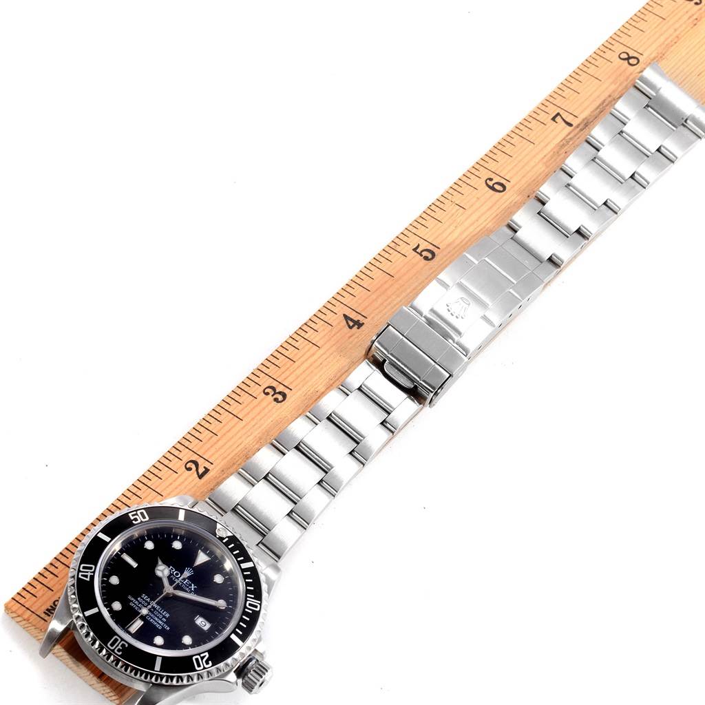 The image shows a Rolex Sea-Dweller 16600 Men
s Stainless Steel Black Dial 16600 Men
s Stainless Steel Black Dial watch laid out flat next to a ruler, displaying its face, band, and clasp.
