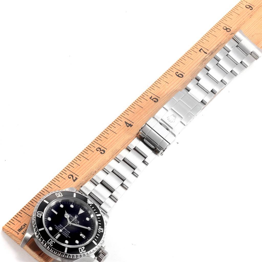 The image shows a top view of the Rolex Sea-Dweller 16600 Men
s Stainless Steel Black Dial 16600 Men
s Stainless Steel Black Dial watch and its metal bracelet, measured against a ruler.