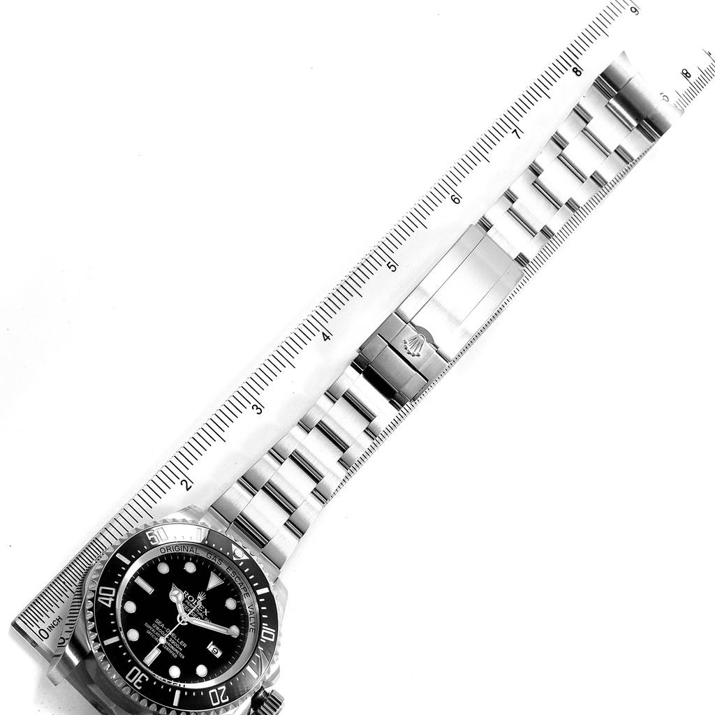 The image shows a top-down view of a Rolex Sea-Dweller 116660 Men's Stainless Steel Black Dial 116660 Men's Stainless Steel Black Dial watch, featuring its face, bezel, and bracelet alongside a measuring ruler.