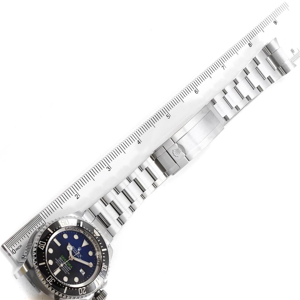 The image shows a top-down view of a Rolex Sea-Dweller 116660 Men's Stainless Steel Blue Dial 116660 Men's Stainless Steel Blue Dial watch with its metal strap fully extended alongside a ruler.