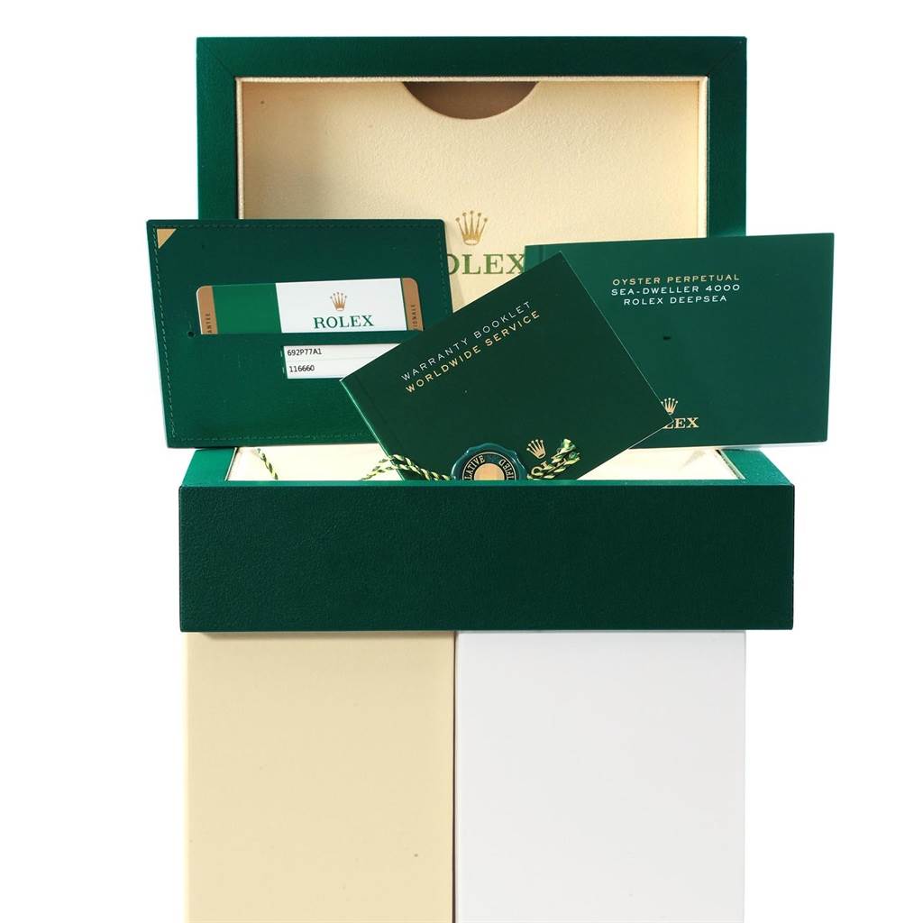 The image shows the packaging and documents, including the warranty booklet, for the Rolex Sea-Dweller 116660 Men's Stainless Steel Blue Dial 116660 Men's Stainless Steel Blue Dial model.