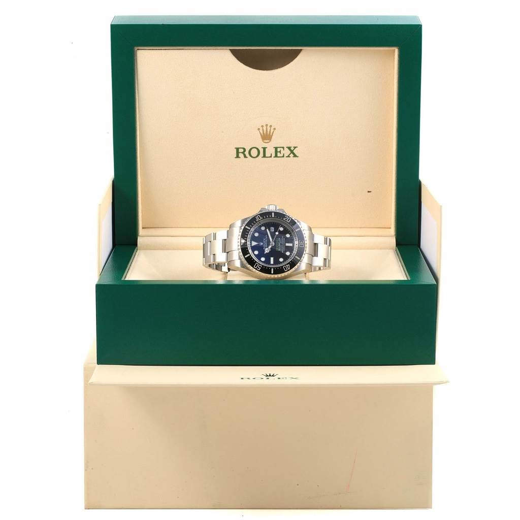 The Rolex Sea-Dweller 116660 Men's Stainless Steel Blue Dial 116660 Men's Stainless Steel Blue Dial watch is displayed front-facing, centered in an open green and beige Rolex box.