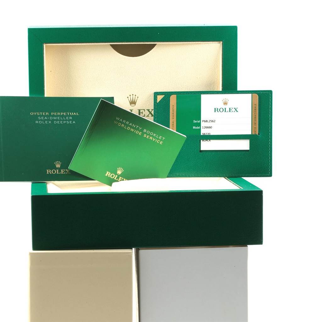 The image shows the packaging, warranty booklets, and certification card for a Rolex Sea-Dweller 126660 Men
s Stainless Steel Black Dial 126660 Men
s Stainless Steel Black Dial watch.