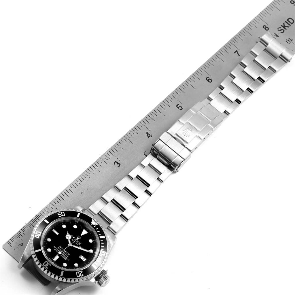 The image shows a top-down view of the Rolex Sea-Dweller 16600 Men
s Stainless Steel Black Dial 16600 Men
s Stainless Steel Black Dial watch, including the watch face, bezel, bracelet, and clasp alongside a ruler.