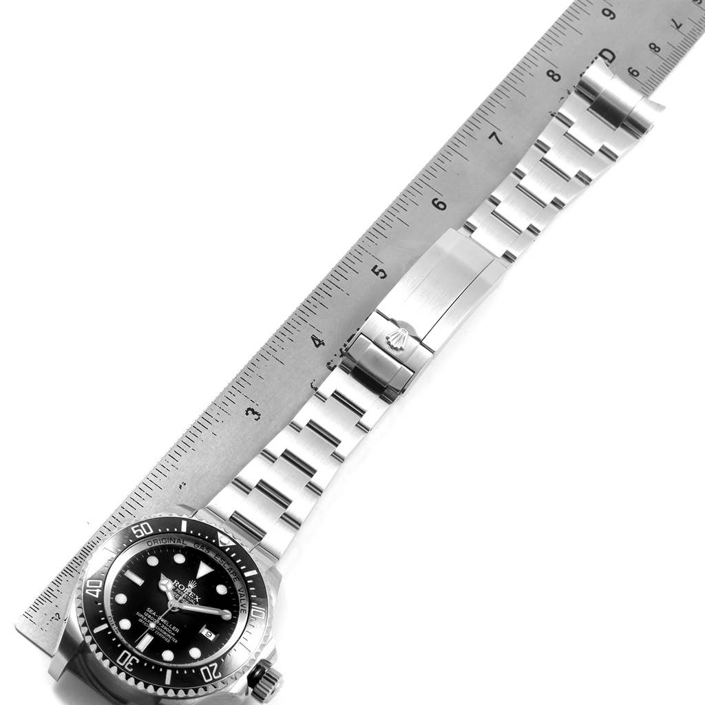 This image shows the Rolex Sea-Dweller 116660 Men
s Stainless Steel Black Dial 116660 Men
s Stainless Steel Black Dial watch laid out flat with a ruler beside it, displaying the face, bezel, and strap.