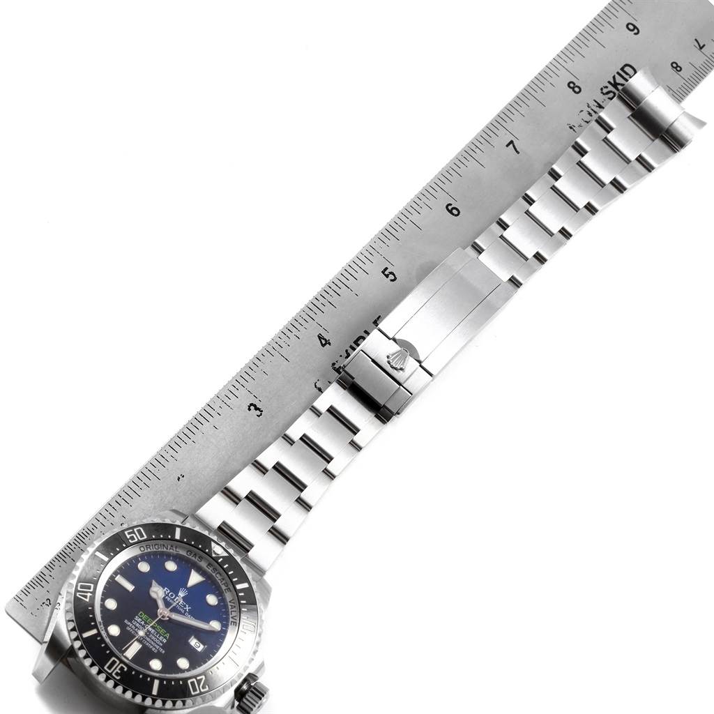 The image shows a top view of the Rolex Sea-Dweller 116660 Men
s Stainless Steel Blue Dial 116660 Men
s Stainless Steel Blue Dial watch, focusing on the dial, bezel, and bracelet, with a ruler for scale.