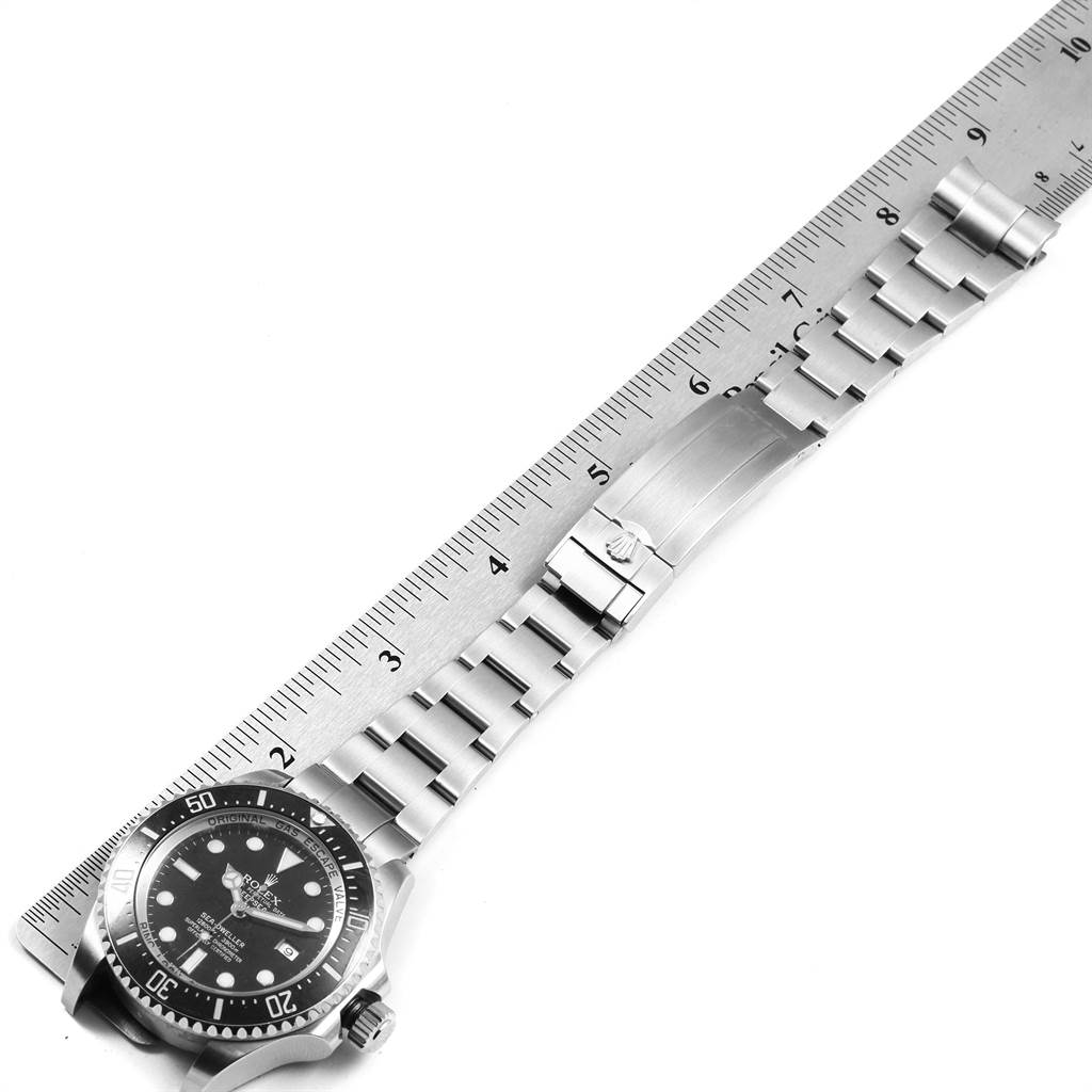The image shows a top view of a Rolex Sea-Dweller 116660 Men
s Stainless Steel Black Dial 116660 Men
s Stainless Steel Black Dial watch, highlighting the watch face and full stainless steel bracelet with a ruler for scale.