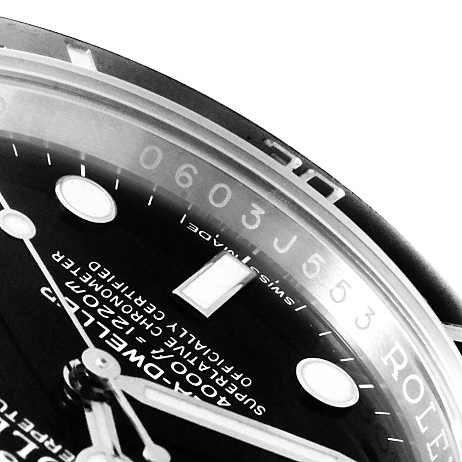The image shows a close-up of the dial and bezel of the Rolex Sea-Dweller 116600 Men
s Stainless Steel Black Dial 116600 Men
s Stainless Steel Black Dial watch at an angle.