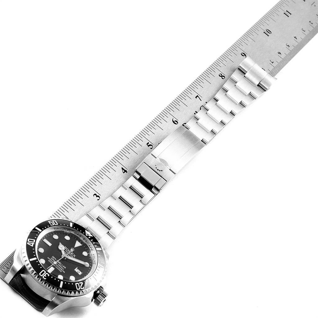 The image shows a Rolex Sea-Dweller 116660 Men
s Stainless Steel Black Dial 116660 Men
s Stainless Steel Black Dial watch from a top-down angle, displaying the face, bezel, and stainless steel bracelet alongside a ruler.