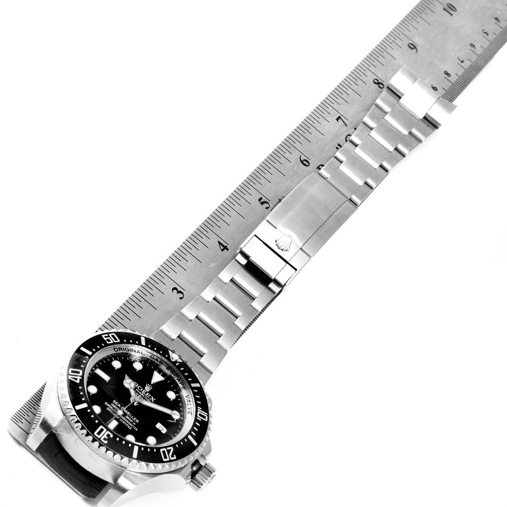 The image shows a top-down view of a Rolex Sea-Dweller 116660 Men
s Stainless Steel Black Dial 116660 Men
s Stainless Steel Black Dial watch with its bracelet next to a ruler for measurement.