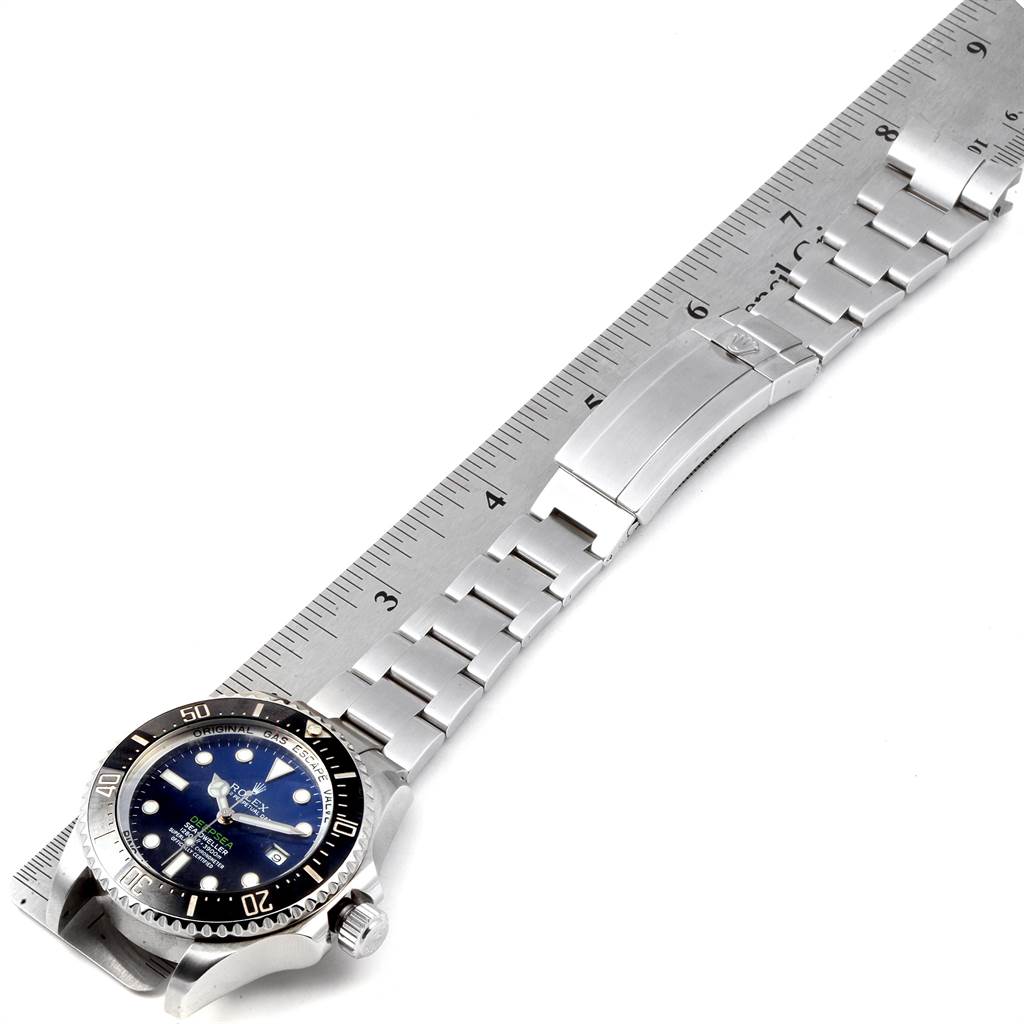 The image shows a side view of a Rolex Sea-Dweller 116660 Men's Stainless Steel Blue Dial 116660 Men's Stainless Steel Blue Dial watch with its stainless steel bracelet extended alongside a ruler for size reference.