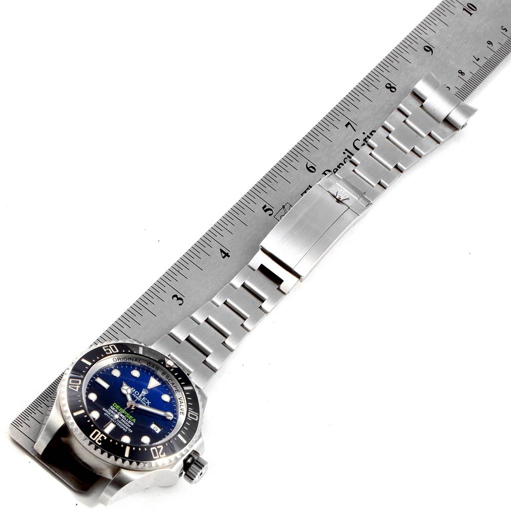 The image shows a side view of the Rolex Sea-Dweller 116660 Men's Stainless Steel Blue Dial 116660 Men's Stainless Steel Blue Dial model with its stainless steel bracelet and clasp against a ruler for scale.