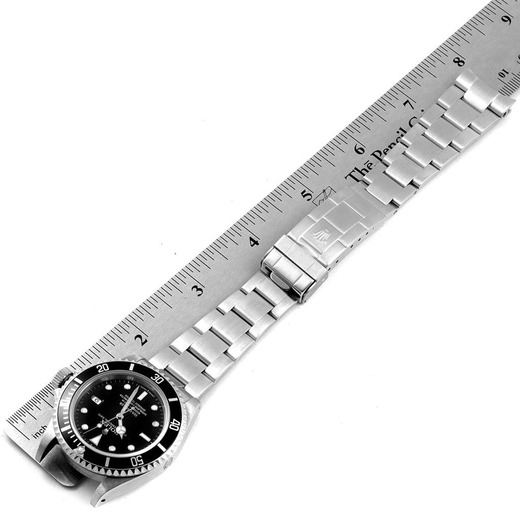 The image shows a Rolex Sea-Dweller 16600 Men
s Stainless Steel Black Dial 16600 Men
s Stainless Steel Black Dial watch laid flat next to a ruler, with the face, bracelet, and clasp visible.