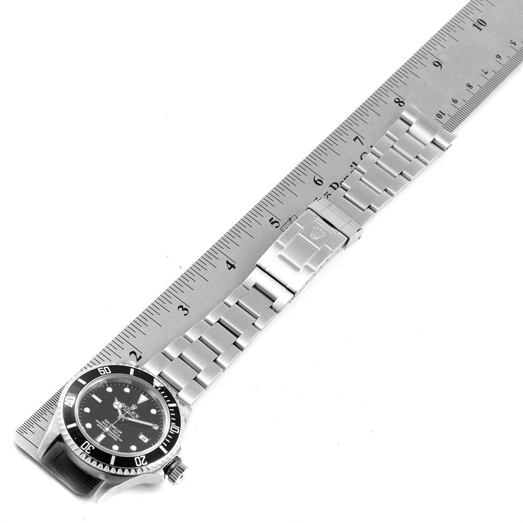The image shows a Rolex Sea-Dweller 16600 Men
s Stainless Steel Black Dial 16600 Men
s Stainless Steel Black Dial watch laid flat alongside a ruler, highlighting its bracelet and clasp.