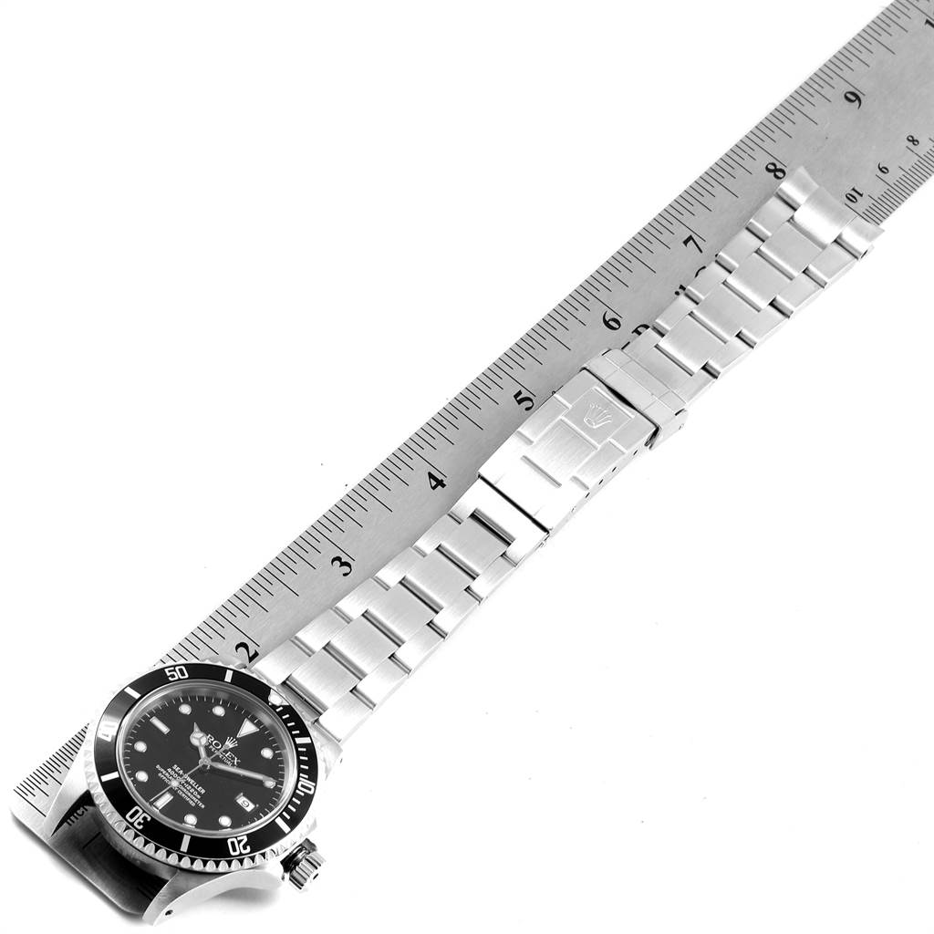 This image shows the full-length view of the Rolex Sea-Dweller 16600 Men
s Stainless Steel Black Dial 16600 Men
s Stainless Steel Black Dial watch, focusing on the face, bezel, and metal bracelet, placed along a ruler.