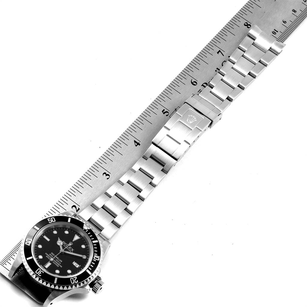 The image shows a Rolex Sea-Dweller 16600 Men
s Stainless Steel Black Dial 16600 Men
s Stainless Steel Black Dial watch laid flat next to a ruler, highlighting the clasp and bracelet.