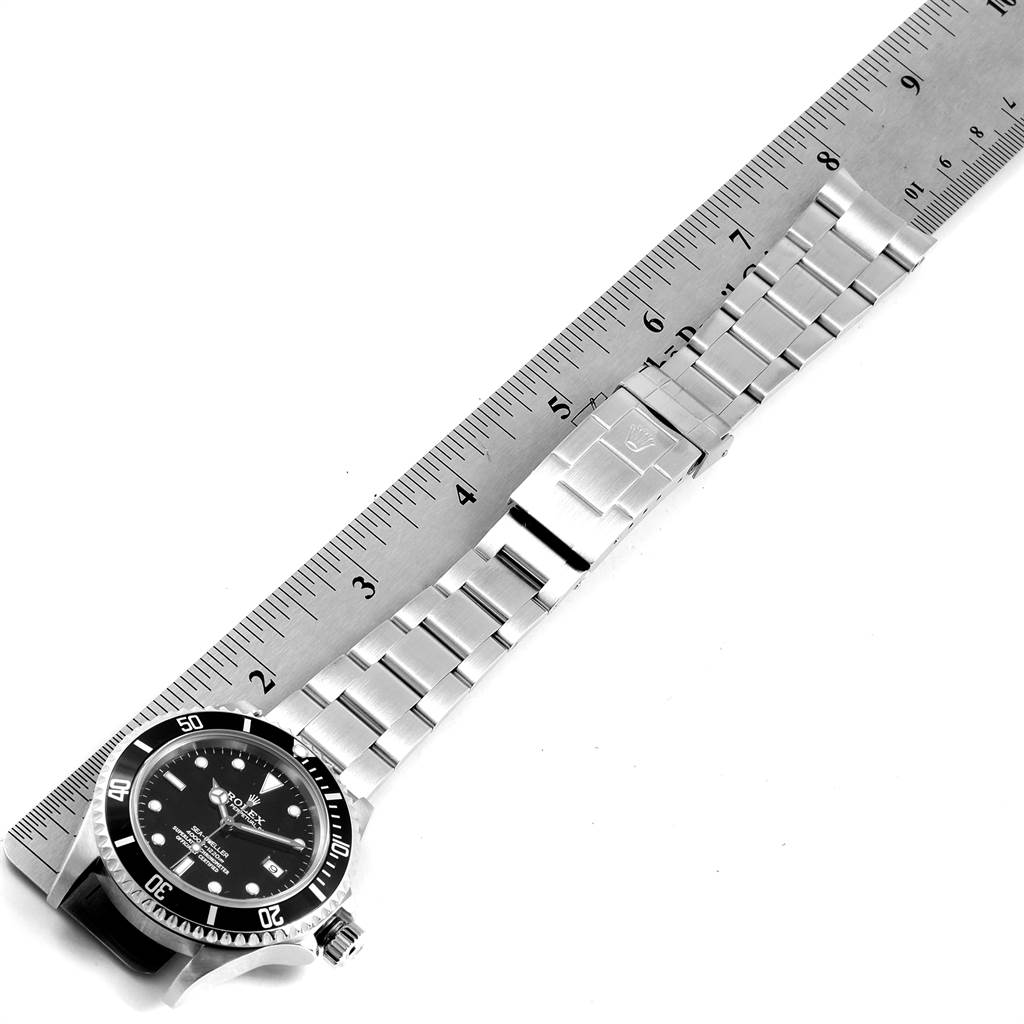 The image shows a Rolex Sea-Dweller 16600 Men
s Stainless Steel Black Dial 16600 Men
s Stainless Steel Black Dial watch laid flat, with a ruler next to it, displaying the clasp and bracelet in full view.