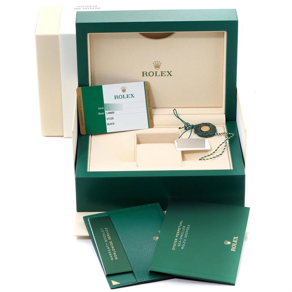 The image shows the packaging and accessories of a Rolex Sea-Dweller 126600 Men
s Stainless Steel Black Dial 126600 Men
s Stainless Steel Black Dial, including paperwork and tags, from a frontal view angle.