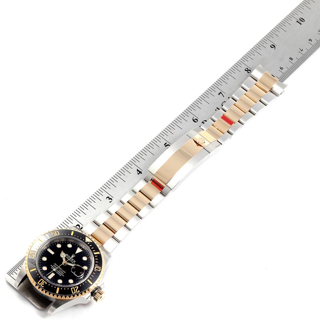 The image shows a Rolex Sea-Dweller 126603 Men's Steel and Gold (two tone) Black Dial 126603 Men's Steel and Gold (two tone) Black Dial watch laid flat against a ruler, displaying the face, bezel, and bracelet.