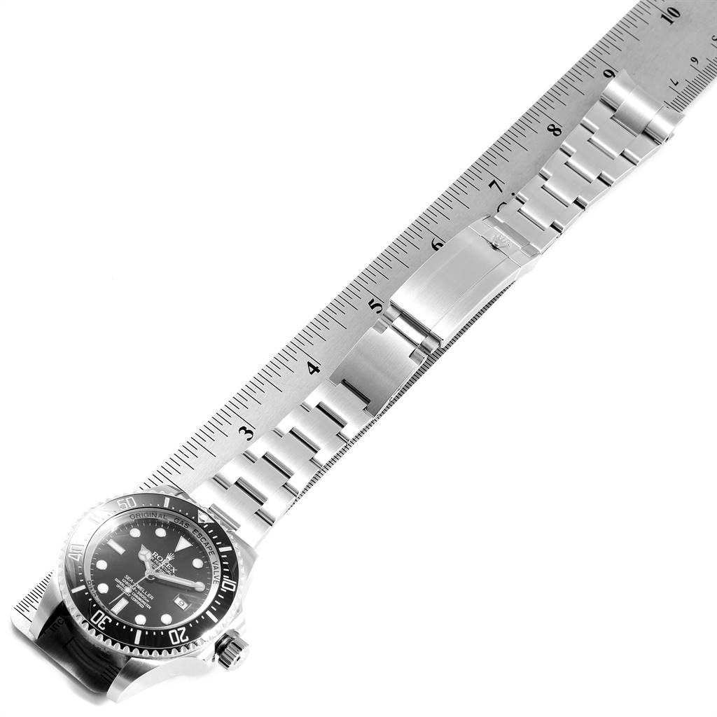 The image shows a top-down view of a Rolex Sea-Dweller 116660 Men
s Stainless Steel Black Dial 116660 Men
s Stainless Steel Black Dial watch with a ruler beside it, highlighting its bracelet.
