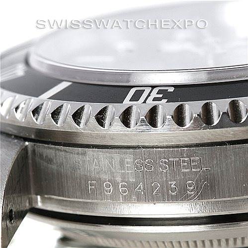 This close-up image of a Rolex Sea-Dweller 16600 Men's Stainless Steel Black Dial 16600 Men's Stainless Steel Black Dial watch shows the bezel, part of the crystal, and the stainless steel casing with the serial number.