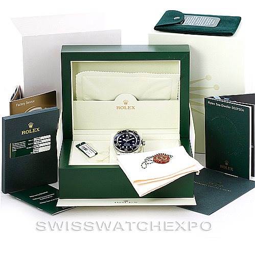 The image shows a Rolex Sea-Dweller 116660 Men
s Stainless Steel Black Dial 116660 Men
s Stainless Steel Black Dial watch at an angle inside its open box, with accompanying booklets and packaging.