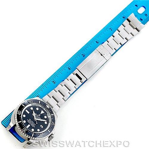 The image shows a Rolex Sea-Dweller 116660 Men's Stainless Steel Black Dial 116660 Men's Stainless Steel Black Dial watch and its metal bracelet laid next to a blue ruler for measurement, pictured from above.