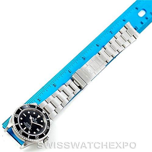 The image shows a Rolex Sea-Dweller 16600 Men's Stainless Steel Black Dial 16600 Men's Stainless Steel Black Dial watch laid flat with its face and metal bracelet visible alongside a blue ruler.