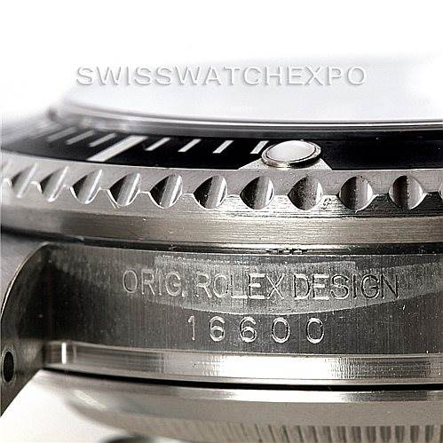 The image shows a close-up of a Rolex Sea-Dweller 16600 Men
s Stainless Steel Black Dial 16600 Men
s Stainless Steel Black Dial model with engraved details and part of the bezel visible.
