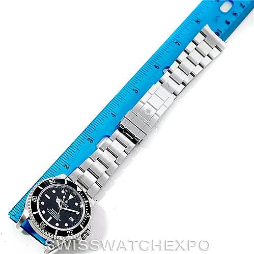 This image shows a top-down view of a Rolex Sea-Dweller 16600 Men's Stainless Steel Black Dial 16600 Men's Stainless Steel Black Dial watch, focusing on the face and bracelet laid next to a blue ruler.