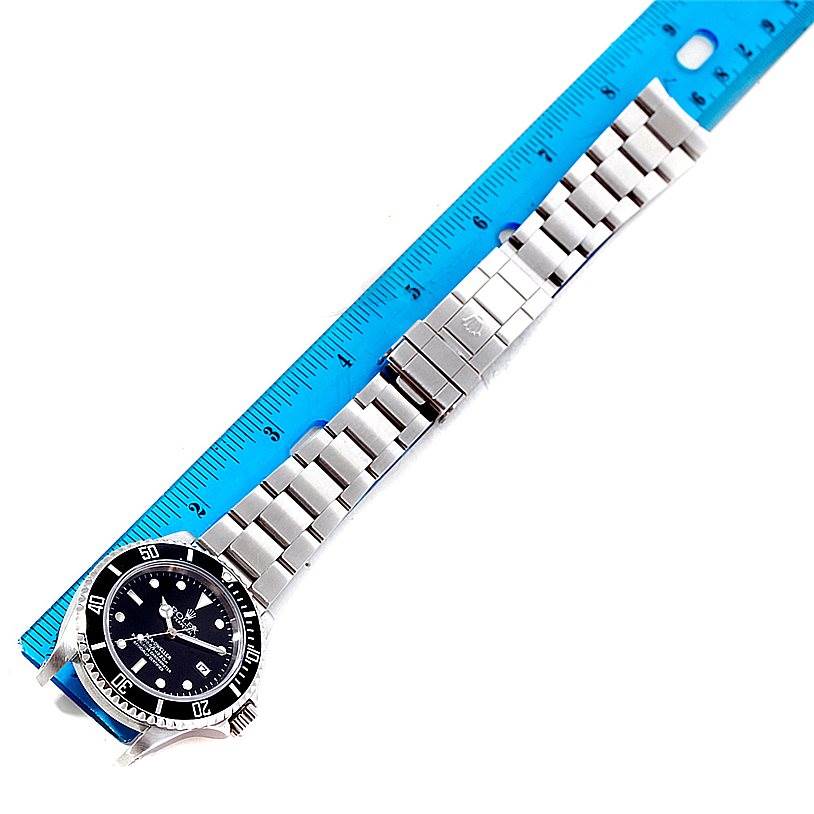 The Rolex Sea-Dweller 16600 Men's Stainless Steel Black Dial 16600 Men's Stainless Steel Black Dial watch is shown laying flat, from a top-down angle, along with a ruler.