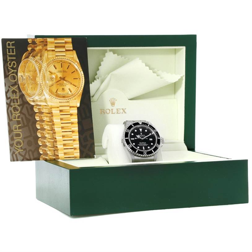 The image shows a Rolex Sea-Dweller 16600 Men
s Stainless Steel Black Dial 16600 Men
s Stainless Steel Black Dial watch from the front, inside its open green and cream box with a booklet inside.