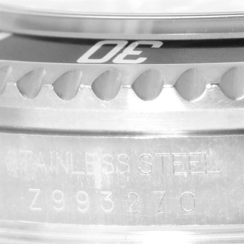 The image shows a close-up of the Rolex Sea-Dweller 16600 Men's Stainless Steel Black Dial 16600 Men's Stainless Steel Black Dial's serrated bezel and part of the case with the serial number and "STAINLESS STEEL" engraving visible.