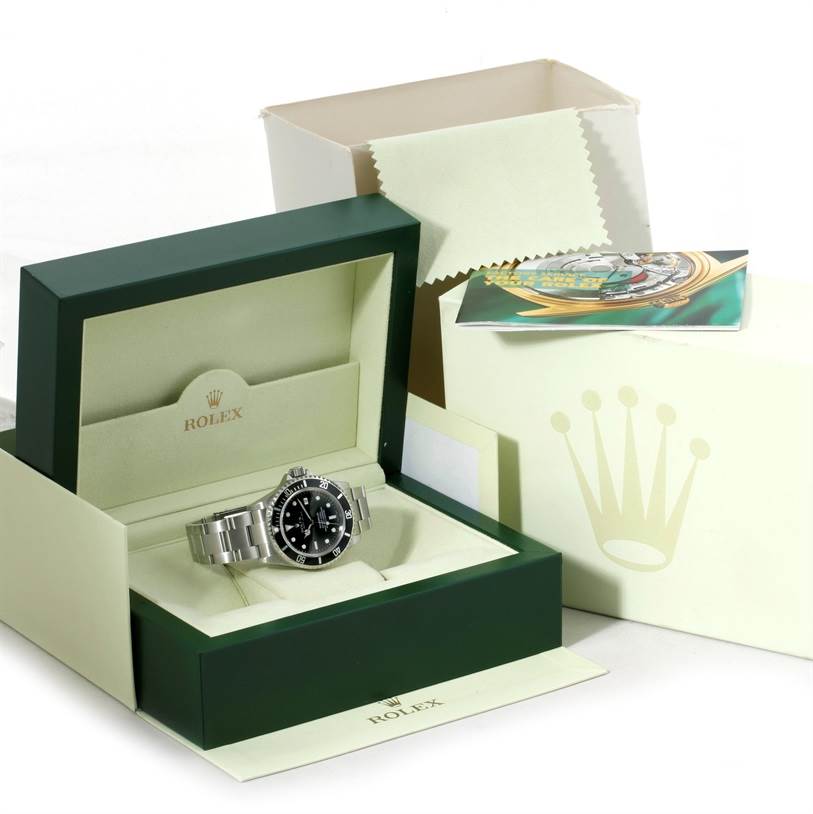 The Sea-Dweller model by Rolex is shown at an angled view inside its green display box, with additional packaging and paperwork visible.